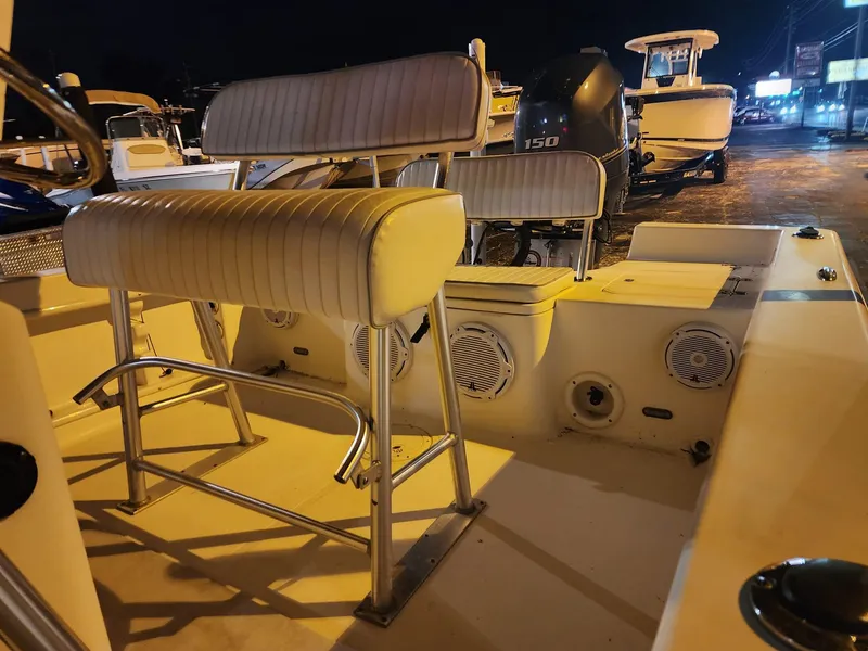 Slide: The Image of 2005 Sea Hunt Navigator 22 boat interior with seating and speakers at night. - 13