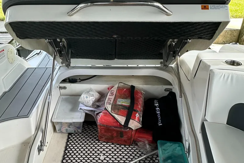 Slide: The Image of Storage compartment of 2022 Chaparral 267 SSX OB boat with various items inside. - 17