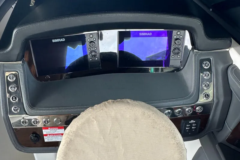 Slide: The Image of 2022 Chaparral 267 SSX OB dashboard with dual Simrad displays and control buttons. - 25