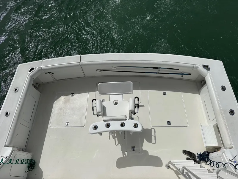 Slide: The Image of 1990 Bertram 50 Convertible boat deck with fishing chair, surrounded by water. - 11