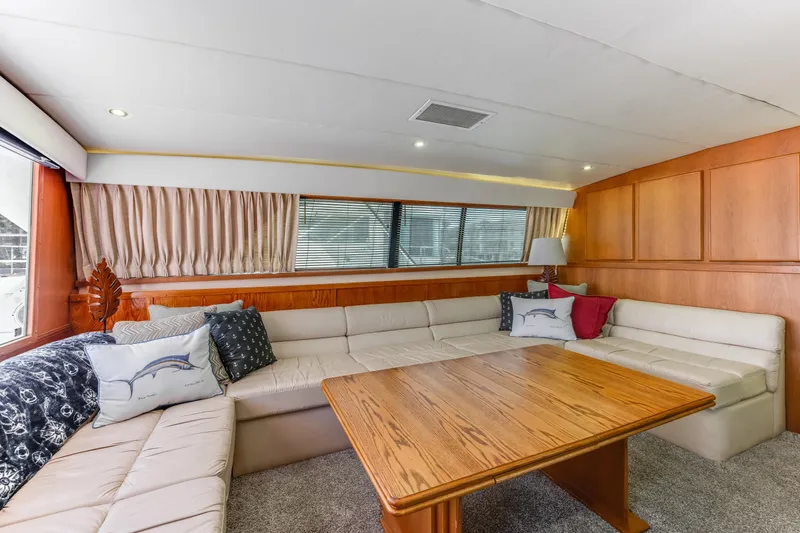 Slide: The Image of Luxurious interior of 1990 Bertram 50 Convertible yacht with plush seating and wooden table. - 13