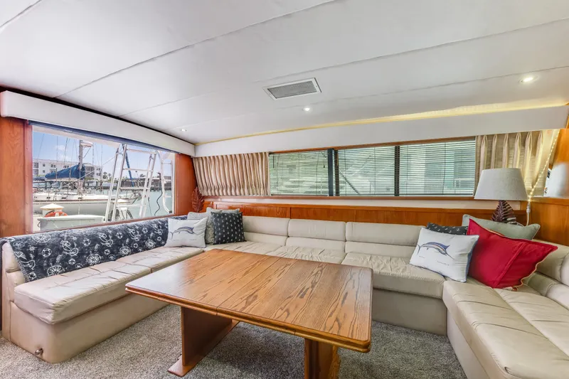 Slide: The Image of Luxurious interior of a 1990 Bertram 50 Convertible yacht with plush seating and wooden table. - 14