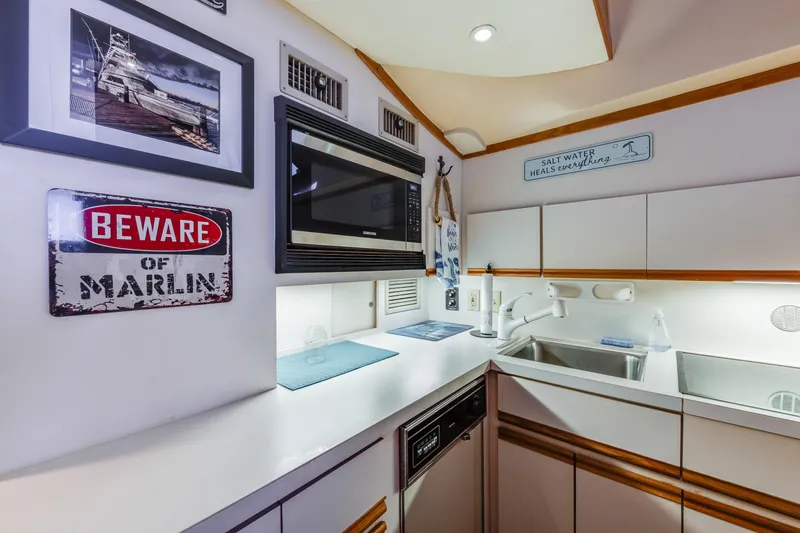 Slide: The Image of 1990 Bertram 50 Convertible yacht kitchen with modern appliances and nautical decor. - 18