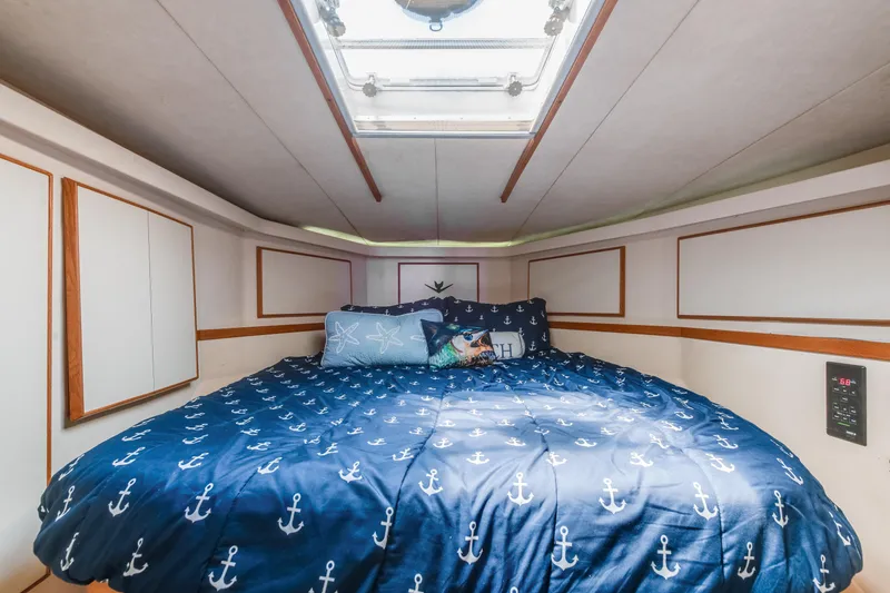 Slide: The Image of Cozy bedroom in 1990 Bertram 50 Convertible yacht with nautical-themed bedding. - 20