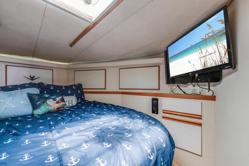 Slide: The Image of Cozy bedroom in 1990 Bertram 50 Convertible yacht with nautical decor and wall-mounted TV. - 21