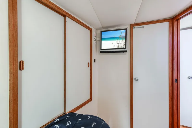 Slide: The Image of Interior of 1990 Bertram 50 Convertible yacht with TV and wooden accents. - 24