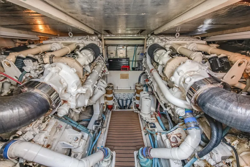 Slide: The Image of Engine room of a 1990 Bertram 50 Convertible yacht, showcasing dual engines and mechanical systems. - 26