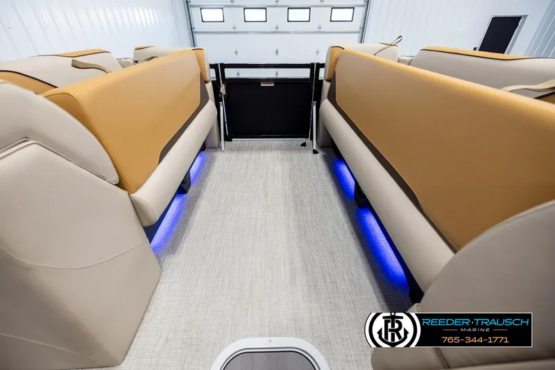 Slide: The Image of 2025 Tahoe SP Cr interior with beige seating and blue LED lighting in a showroom. - 19