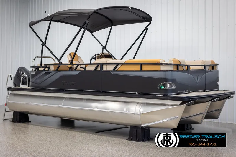 Slide: The Image of 2025 Tahoe SP Cr pontoon boat with canopy, displayed indoors at Reeder-Trausch Marine. - 3