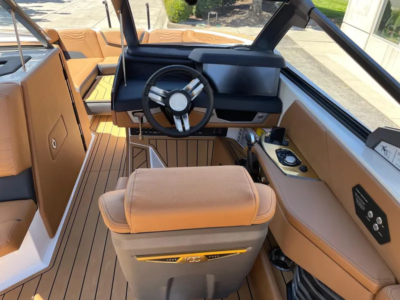 Slide: The Image of 2025 Nautique Super Air Nautique G25 interior with tan leather seats and modern dashboard. - 13