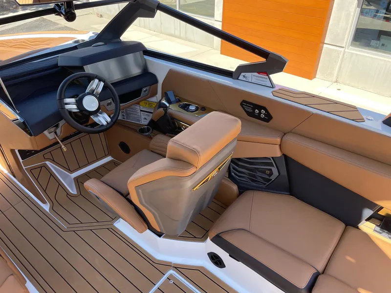 Slide: The Image of 2025 Nautique Super Air Nautique G25 interior with luxurious tan seating and modern dashboard. - 6