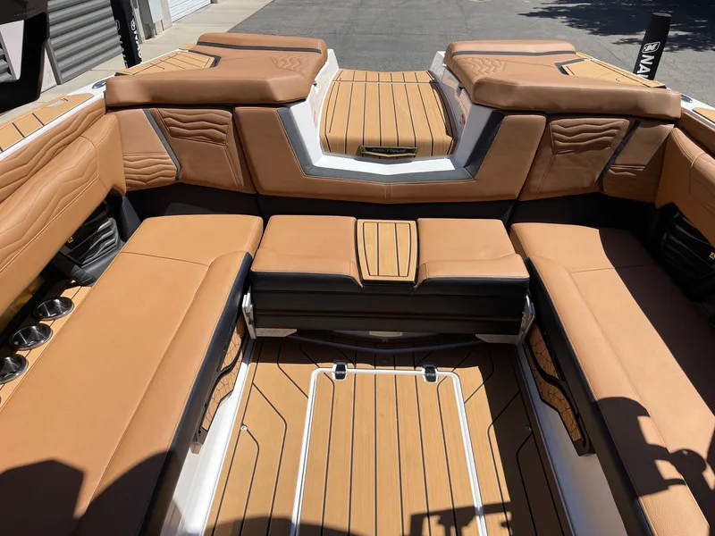 Slide: The Image of 2025 Nautique Super Air Nautique G25 interior with tan leather seating and teak flooring. - 8