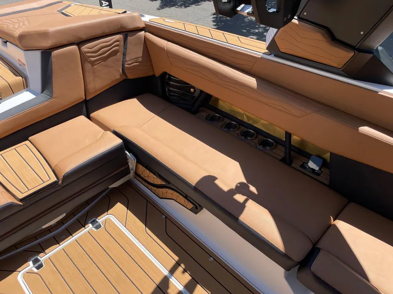 Slide: The Image of 2025 Nautique Super Air Nautique G25 interior with tan leather seating and cup holders. - 9