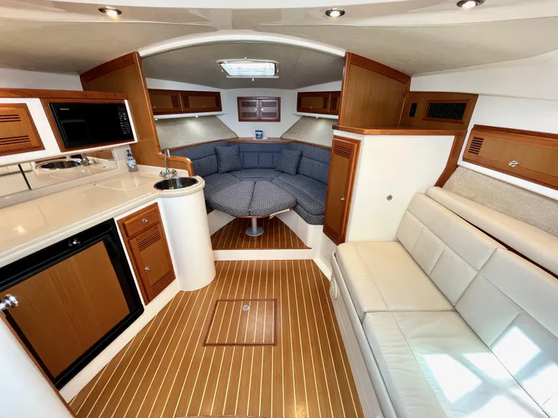 Slide: The Image of Interior of 1999 Cabo 31 Express boat with kitchenette and seating area. - 1