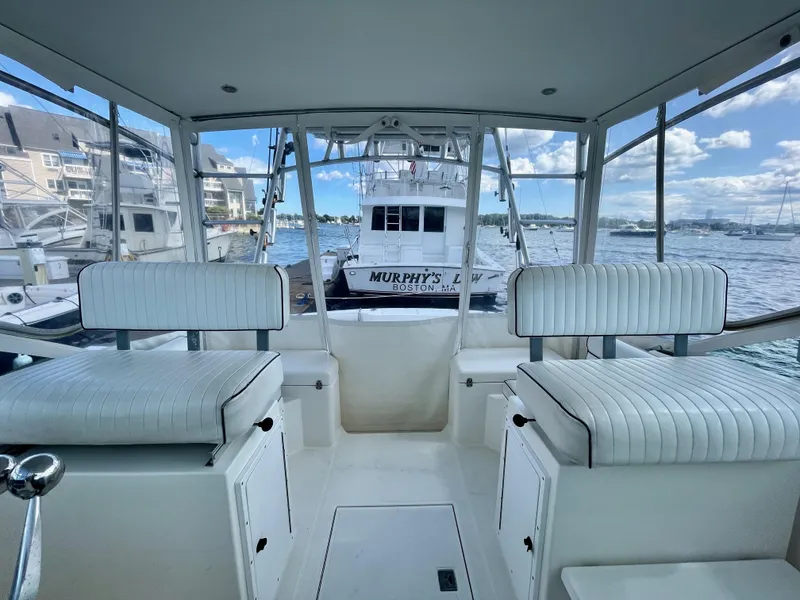 Slide: The Image of 1999 Cabo 31 Express boat interior with white seating, docked at marina. - 13