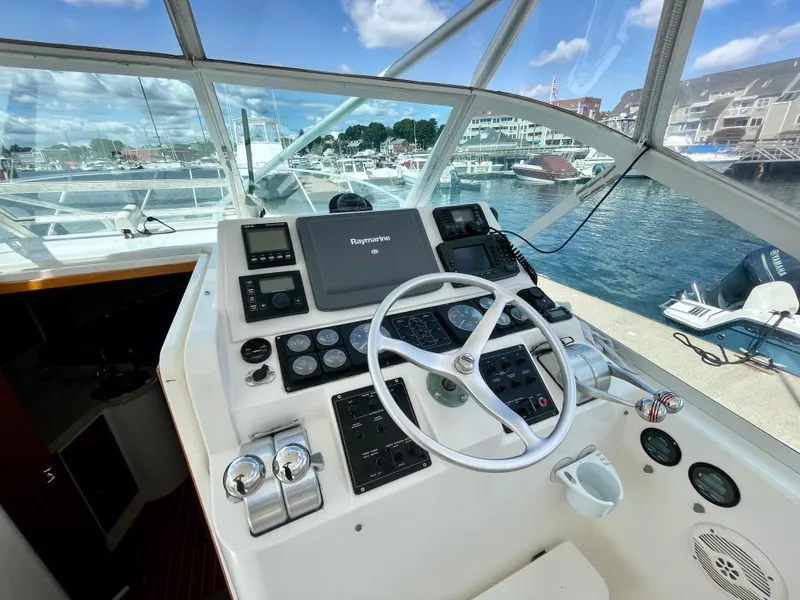 Slide: The Image of Helm of 1999 Cabo 31 Express boat with steering wheel and navigation equipment, docked at marina. - 15