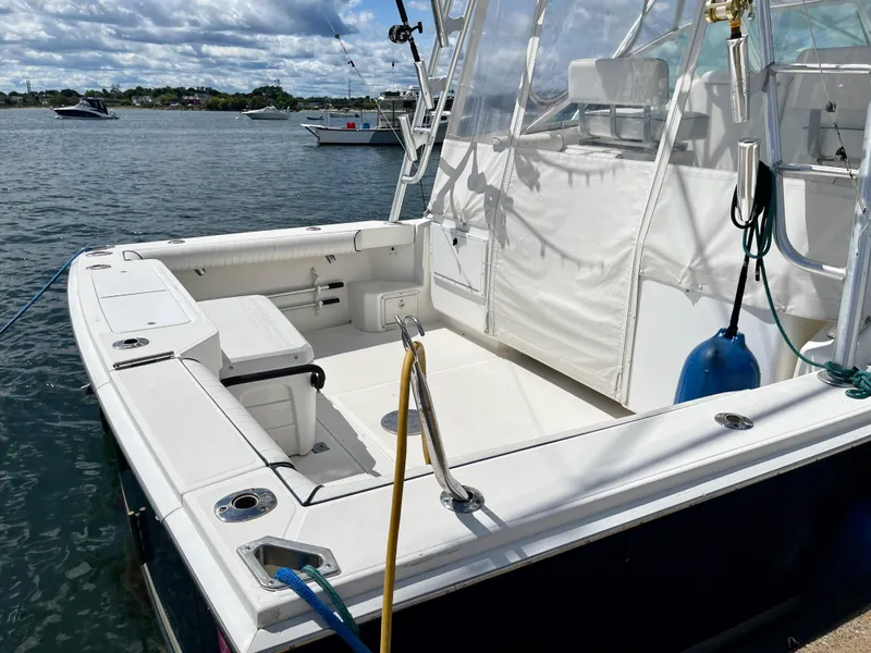 Slide: The Image of 1999 Cabo 31 Express boat docked, featuring spacious deck and seating area. - 18