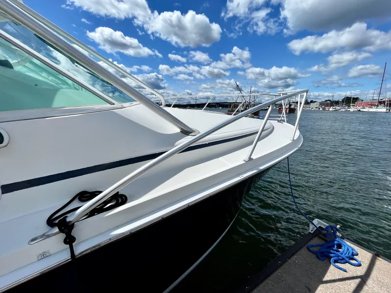 Slide: The Image of 1999 Cabo 31 Express boat docked by the water under a blue sky with clouds. - 20