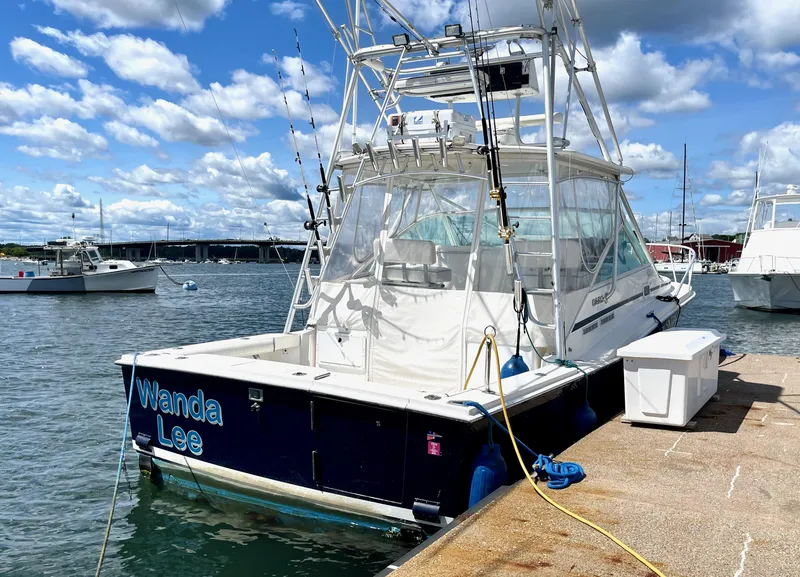 Slide: The Image of 1999 Cabo 31 Express boat docked under a partly cloudy sky. - 21