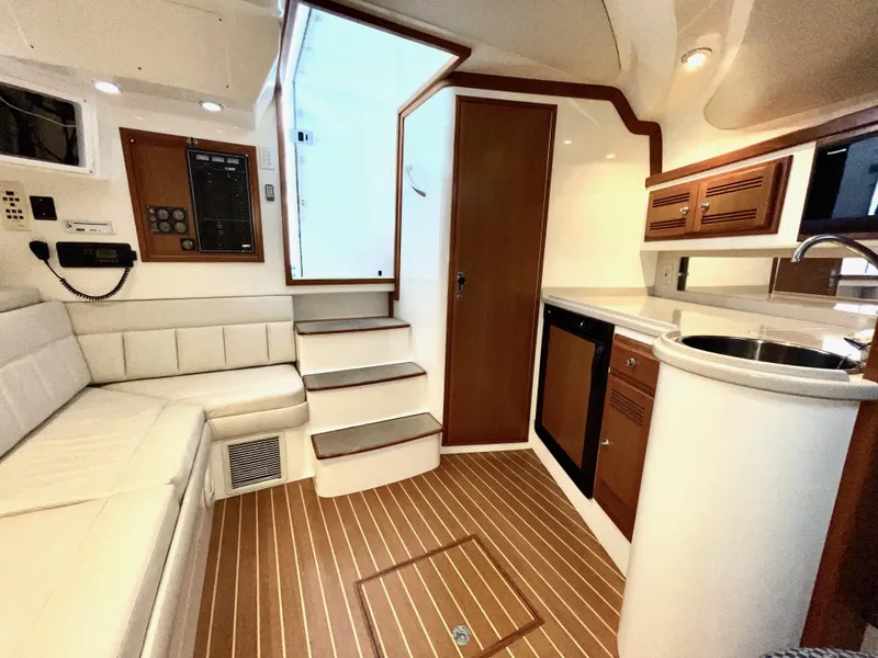 Slide: The Image of Interior of 1999 Cabo 31 Express boat with seating, kitchenette, and wooden flooring. - 3