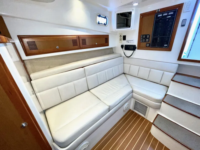 Slide: The Image of 1999 Cabo 31 Express cabin interior with white seating and wooden accents. - 6