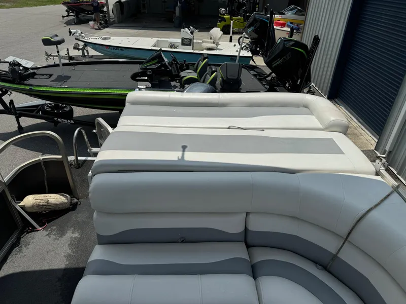 Slide: The Image of 2007 SunChaser 8522 Cruise RE pontoon boat with cushioned seating and nearby fishing boats. - 5