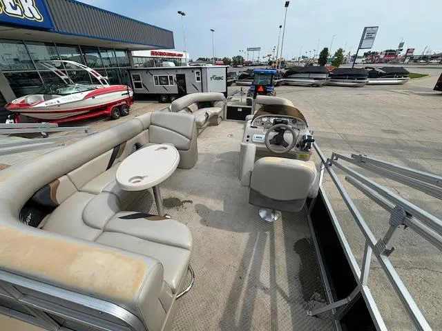 Slide: The Image of 2012 SunChaser 8522 C-N-F pontoon boat with beige seating at a dealership. - 23