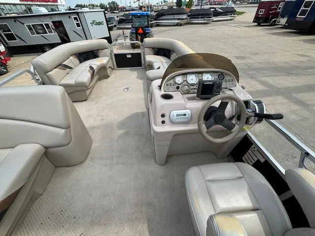 Slide: The Image of 2012 SunChaser 8522 C-N-F pontoon boat interior with beige seating and control panel. - 24