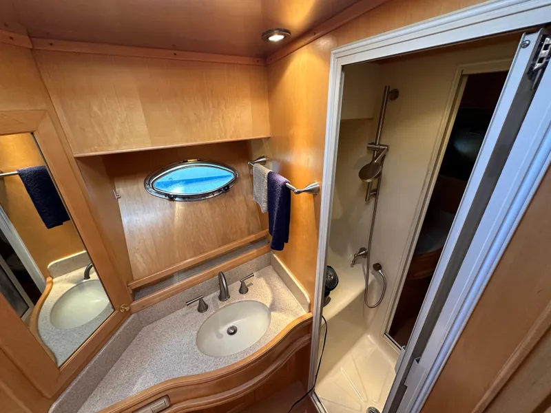 Slide: The Image of 1999 McKinna 47 Sedan yacht bathroom with sink, mirror, and shower. - 14