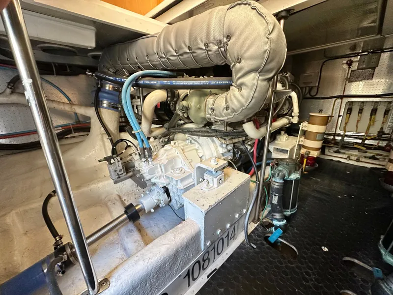 Slide: The Image of Engine room of 1999 McKinna 47 Sedan yacht, showcasing mechanical components and piping. - 16