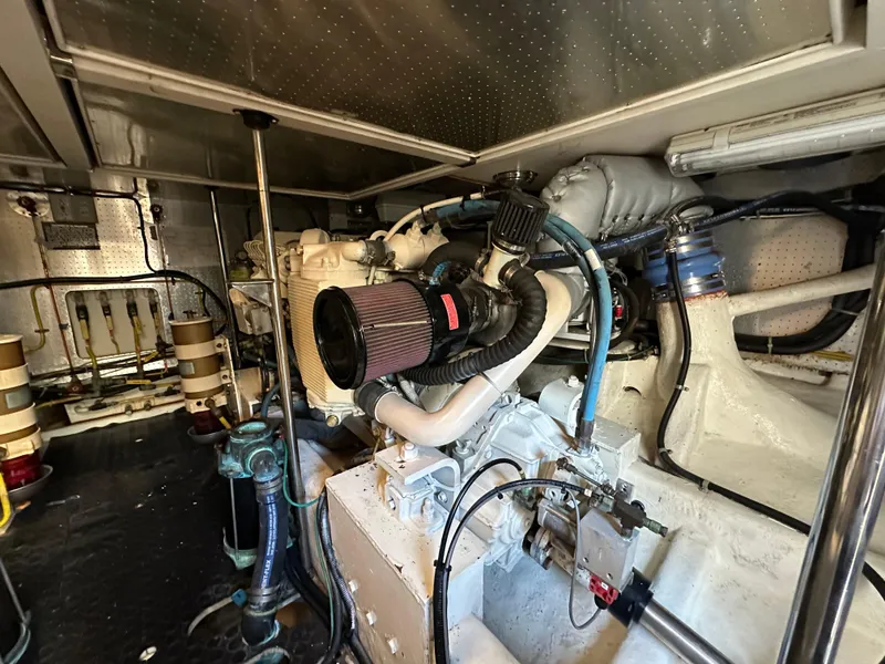 Slide: The Image of Engine room of a 1999 McKinna 47 Sedan yacht, showcasing mechanical components. - 17