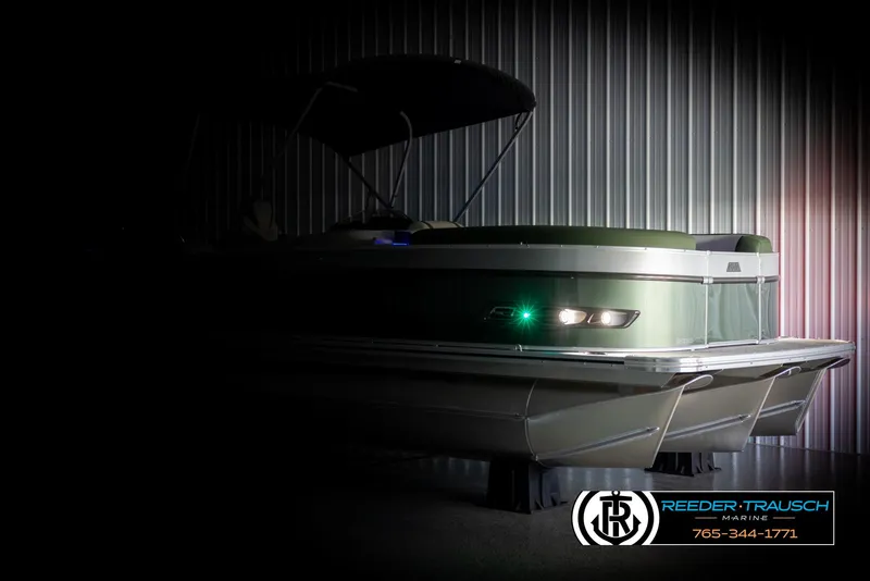 Slide: The Image of 2025 Avalon Catalina EL pontoon boat in dimly lit showroom. - 4