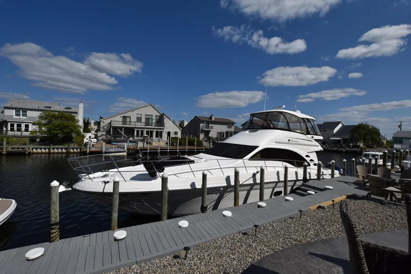 Slide: The Image of 2006 Sea Ray 58 Sedan Bridge yacht docked in a scenic marina. - 0