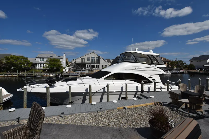 Slide: The Image of 2006 Sea Ray 58 Sedan Bridge yacht docked in a scenic marina. - 1
