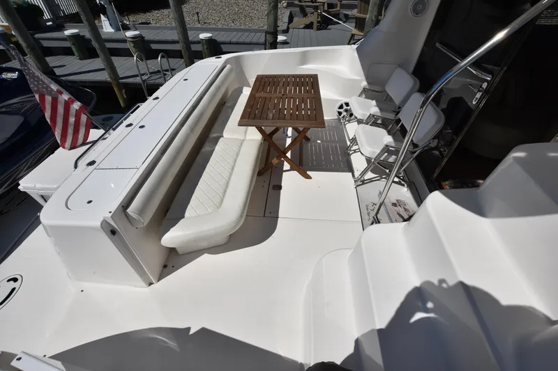 Slide: The Image of 2006 Sea Ray 58 Sedan Bridge yacht deck with seating and table. - 10