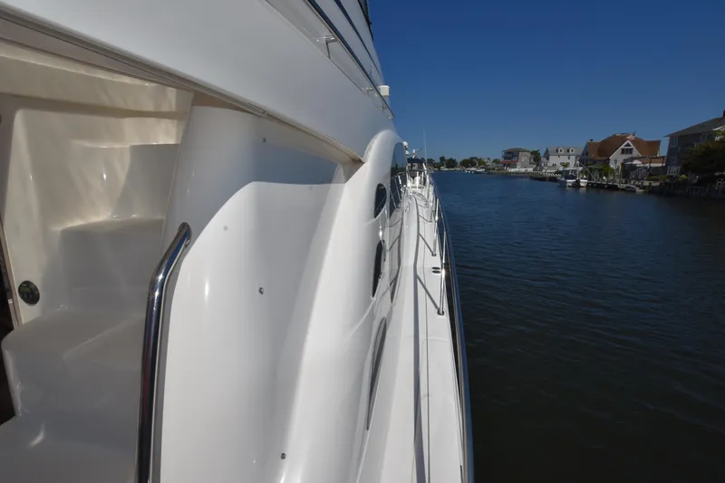 Slide: The Image of 2006 Sea Ray 58 Sedan Bridge yacht on a serene waterway. - 25