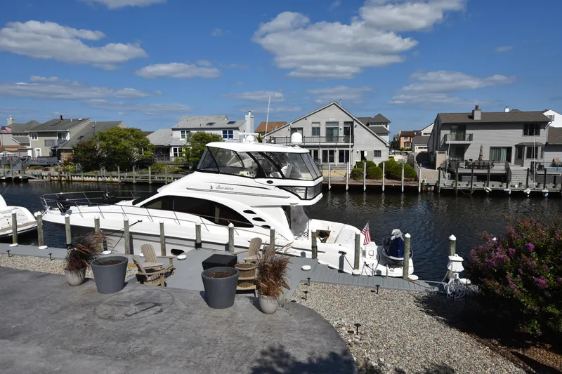 Slide: The Image of 2006 Sea Ray 58 Sedan Bridge yacht docked in a scenic residential canal. - 3