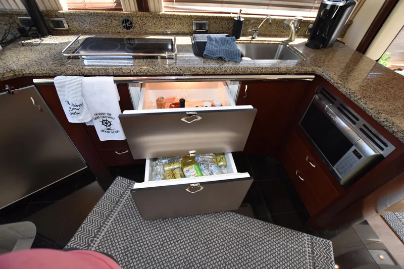 Slide: The Image of Luxurious 2006 Sea Ray 58 Sedan Bridge yacht kitchen with open drawers and modern appliances. - 45