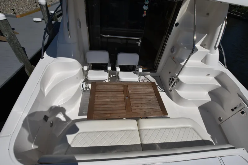 Slide: The Image of 2006 Sea Ray 58 Sedan Bridge yacht cockpit with seating and wooden table. - 8