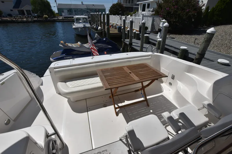 Slide: The Image of 2006 Sea Ray 58 Sedan Bridge yacht deck with seating and wooden table. - 9