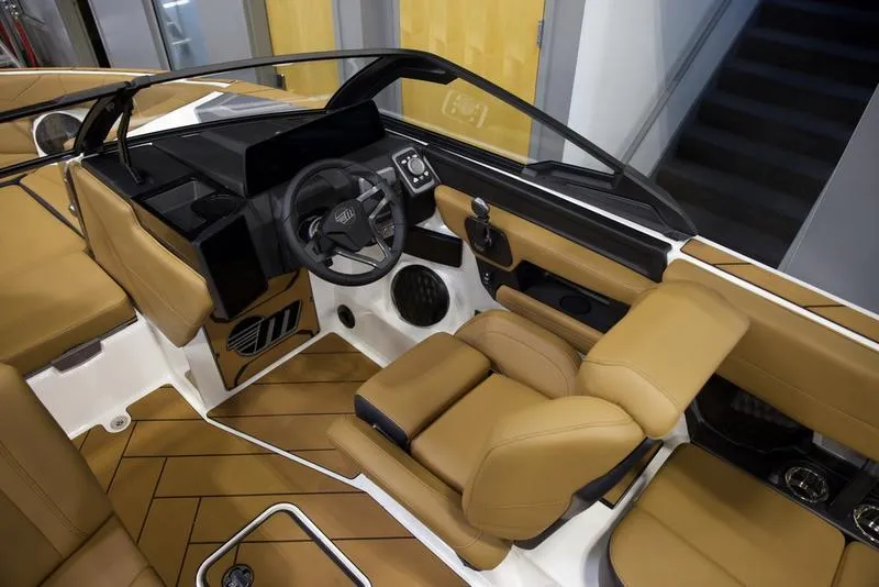 Slide: The Image of 2025 Malibu 23 LSV boat interior with tan leather seats and modern dashboard. - 12