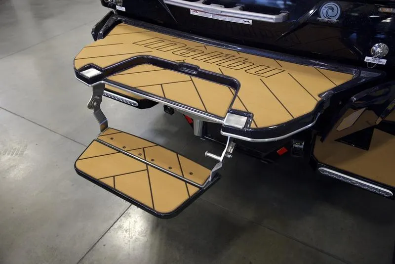 Slide: The Image of 2025 Malibu 23 LSV swim platform with foldable step, featuring tan and black design. - 5