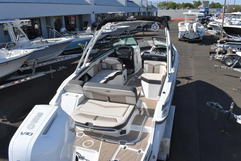Slide: The Image of 2023 Monterey 255SS boat with spacious seating at a marina. - 14