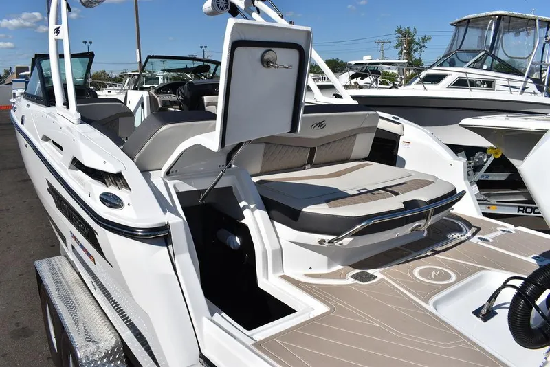 Slide: The Image of 2023 Monterey 255SS boat with open deck and seating, displayed at a marina. - 25