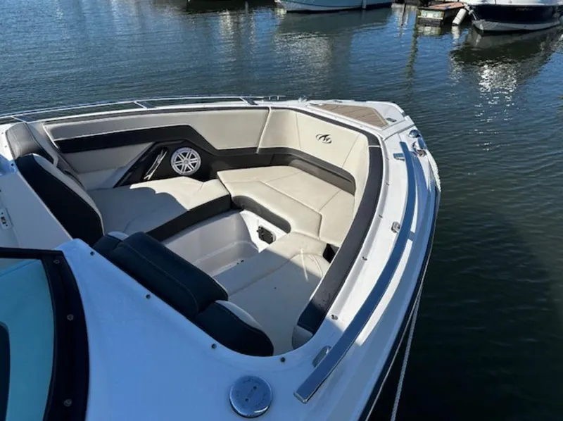 Slide: The Image of 2023 Monterey 255SS boat with spacious seating, docked on calm water. - 5