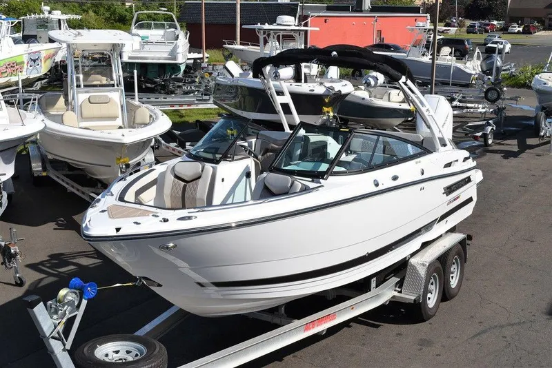 Slide: The Image of 2023 Monterey 255SS boat on trailer, surrounded by other boats in a marina. - 6