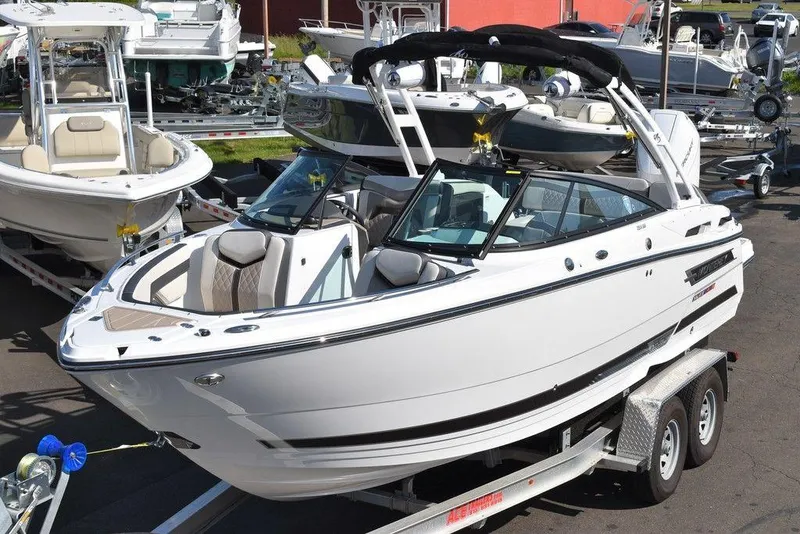 Slide: The Image of 2023 Monterey 255SS boat on trailer, sleek white design, parked in marina. - 7