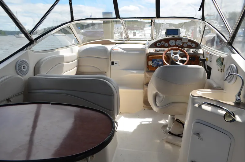 Slide: The Image of Interior of a 2006 Larson Cabrio 240 boat with steering wheel and seating area. - 11