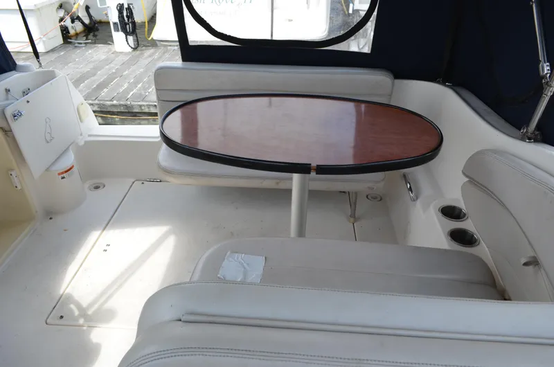 Slide: The Image of 2006 Larson Cabrio 240 boat interior with oval table and cushioned seating. - 13