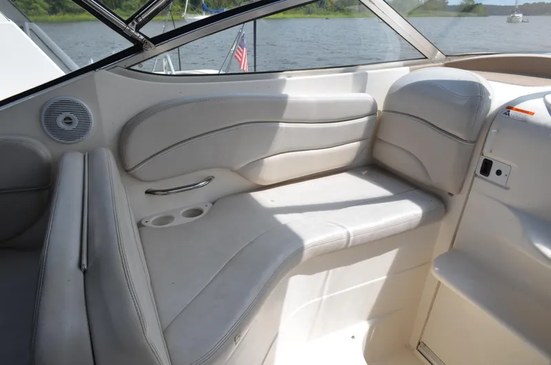 Slide: The Image of 2006 Larson Cabrio 240 boat interior with white seating and cup holders. - 15